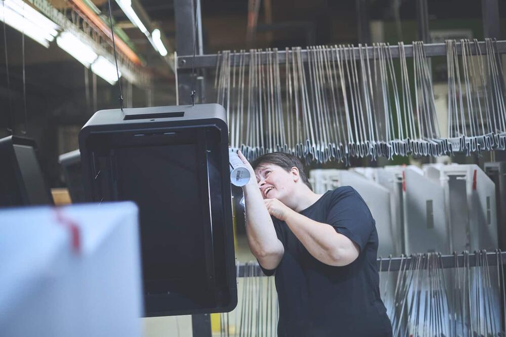 Employee of WAAK Metal Assembly is spray painting a letter box